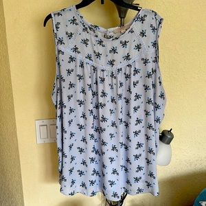 Light blue background with little blue, brown, yellow flowers shirt.